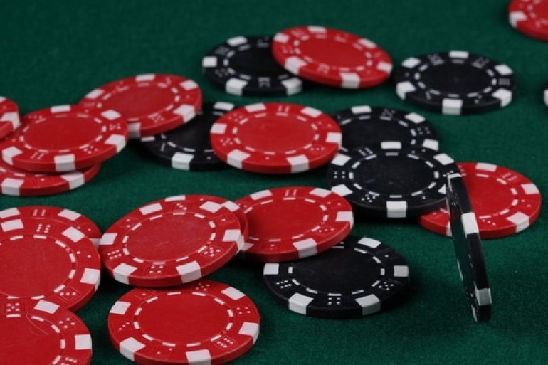 Красные и черные фишки на зеленом столе казино
