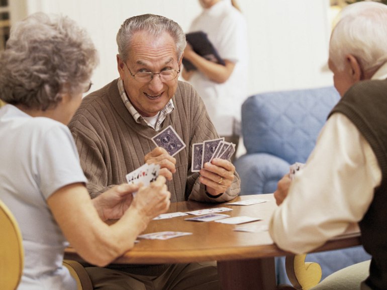 пожилые люди играют в карточные игры
